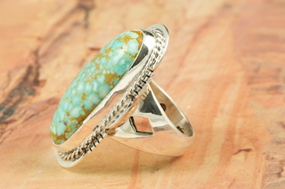 Genuine Number 8 Turquoise set in Sterling Silver Ring. The Number 8 mine is located in Eureka County Nevada. Since 1976 there has been no Number 8 Turquoise mined. There is however, an existing stock pile that Mr. Dowell Ward, the last owner of the Number 8 mine, had stocked away for later sorting. The Turquoise is a collector's item--because once the reserve is gone there will be no more material released onto the market. The Gold Mining Company owns the claim to the Number 8 mine and it has been swallowed up by the gold mining operations. This is some of the last Number 8 Turquoise to be had and will be a great addition to your collection. Created by Navajo Artist Margaret Platero. Signed by the artist.